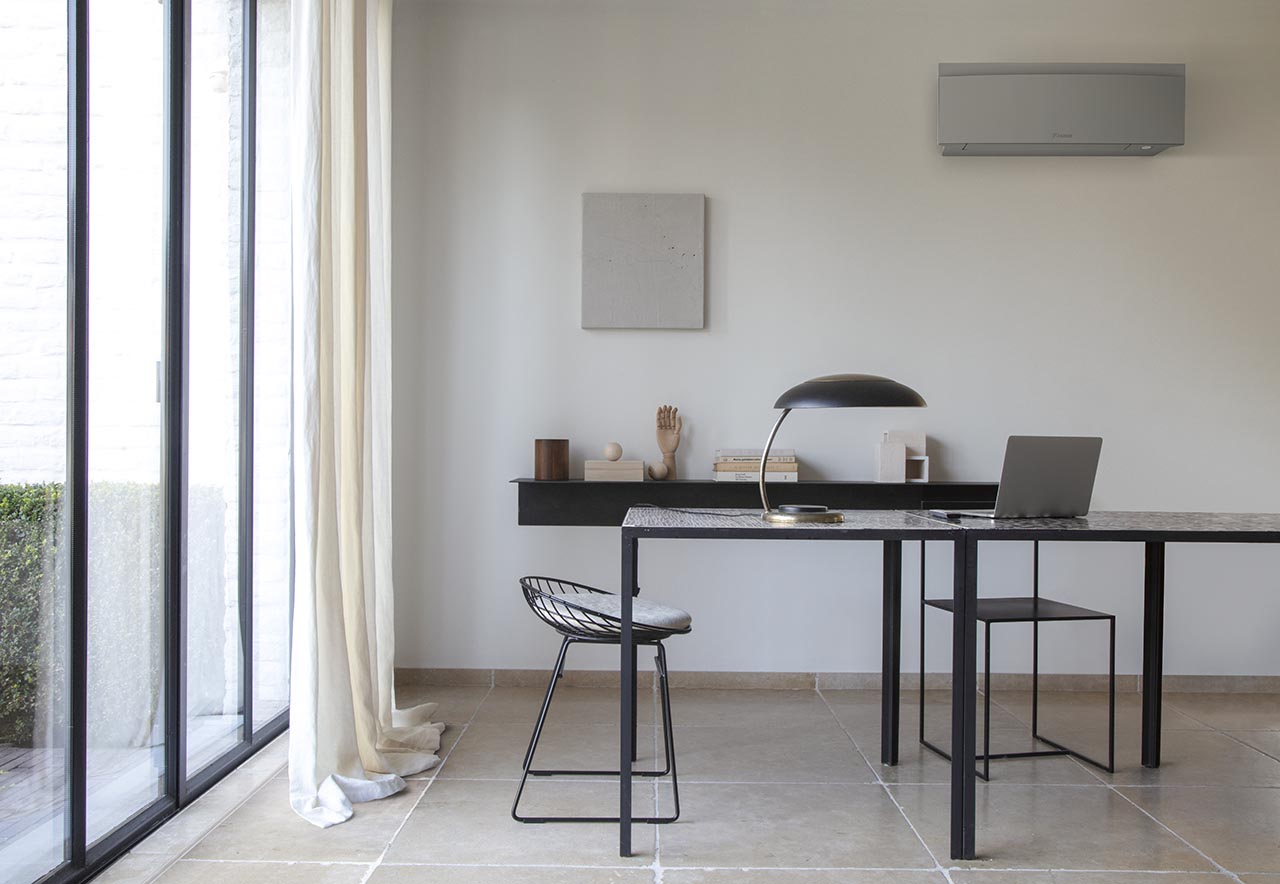 Sidabrinis Daikin Emura FTXJ25AS moderniame interjere